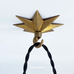 a gold star hanging on a black rope