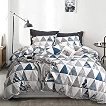 a bedroom with a bed covered in a blue and white quilted comforter set