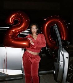 a woman standing in front of a car with the number 20 on it