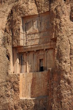 an ancient building carved into the side of a mountain