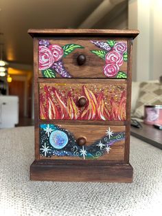 a wooden drawer with flowers painted on it