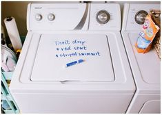 a dryer sitting on top of a washer next to a pile of clothes