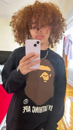 a woman taking a selfie in front of her mirror wearing a bathing ape sweatshirt