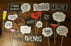 a bunch of signs that are on top of a wooden table with some writing on them