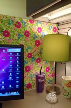 a desktop computer sitting on top of a desk next to a lamp and coffee cup