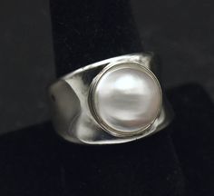 Beautiful vintage sterling silver ring, bezel set with a lovely and large akoya pearl. A smart, sleek, modern design. The pearl is approximately 1/2 inch in diameter. Size 9 1/4 11.4g Marked "925 WW HONG KONG" Classic Silver Cabochon Pearl Ring, Classic Silver Pearl Ring With Polished Finish, Modern Silver Pearl Ring, Silver Pearl Ring, Ring Bezel, Vintage Sterling Silver Rings, Akoya Pearls, Vintage Ring, Silver Pearls