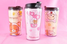 three travel mugs are shown on a pink background with hearts and animals in them