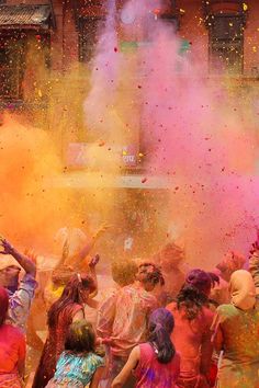 many people are throwing colored powder on each other in the middle of an outdoor event