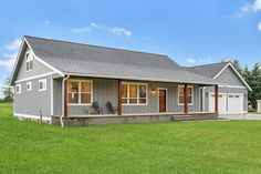 a gray house sitting on top of a lush green field