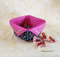 a pink and white polka dot fabric basket with candy in it