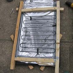 an outdoor grill being prepared for use on the ground with other items around it, including tools and construction materials