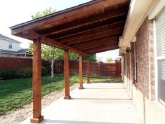 an outdoor covered patio area with grass and trees