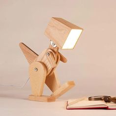 a wooden desk lamp sitting next to an open book