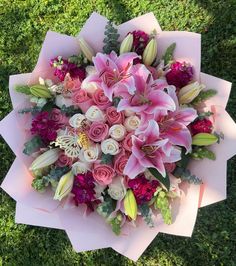 a bouquet of pink flowers sitting on top of green grass