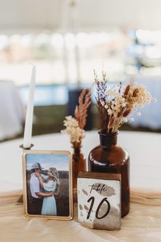 two vases with flowers are sitting on a table next to a sign that says the ten