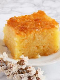 a piece of pineapple upside down cake on a white plate with flowers next to it