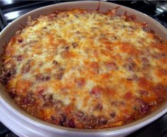 a casserole dish with cheese and meat in it on top of the stove