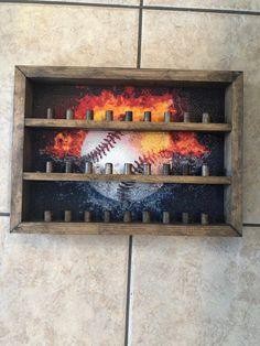 a wooden shelf filled with candles and a baseball painted on the wall next to it