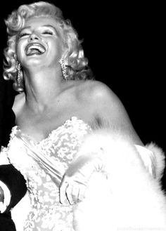 marilyn monroe laughing and wearing a fur coat