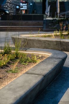 a skateboarder is doing a trick on the edge of a concrete bench in front of a building