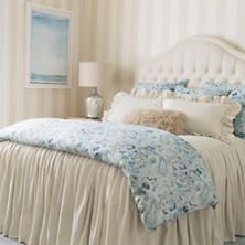 a bed with blue and white comforters in a bedroom