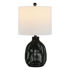 a black table lamp with a white shade on the base and a light in front of it