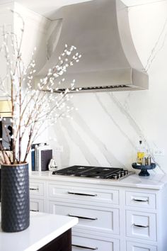 White kitchen with a metal hood and slab backsplash Range Hoods, Traditional Kitchen Designs, Metal Range Hood, Classic White Kitchen, Traditional Kitchen Design, Bright Kitchens