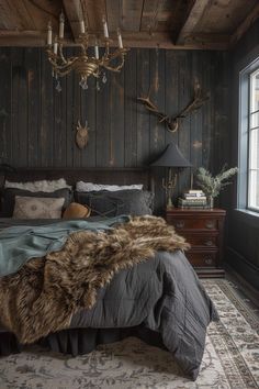 a rustic bedroom with antlers on the wall and wood paneled walls, along with a large bed