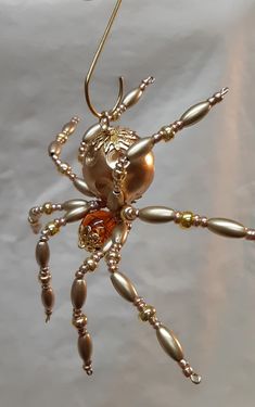 a gold and silver spider ornament hanging from a hook