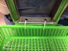 a green shopping basket sitting on top of a floor