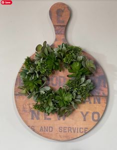 a wooden cutting board with a wreath on it