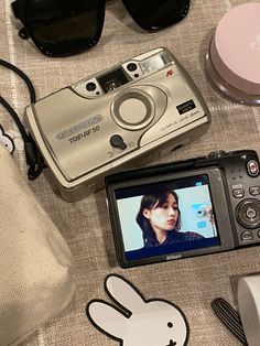 a camera and some other items sitting on a table next to each other with sunglasses