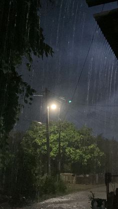 a street light sitting on the side of a road under a cloudy sky at night