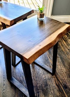 two wooden tables sitting on top of a hard wood floor next to a planter