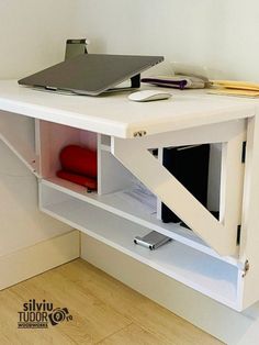 a white desk with a laptop on top and a red chair in the corner next to it