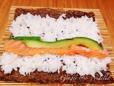 a piece of bread with rice, salmon and cucumber on it