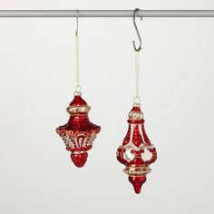 two red glass ornaments hanging from a clothes line