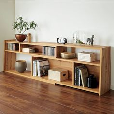 a wooden shelf with books and vases on it