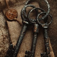 two old keys laying on top of a piece of cloth