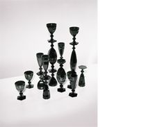 a group of black glass candlesticks sitting next to each other