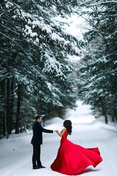 a man and woman dressed in red dancing in the snow