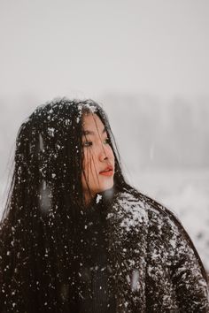 a woman standing in the snow with her eyes closed