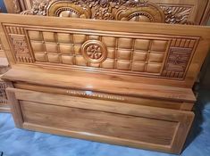 a wooden bed frame with carvings on it