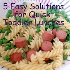 a white plate topped with pasta and sausage next to green peas on top of it