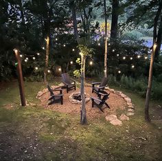 an outdoor fire pit surrounded by chairs and lights