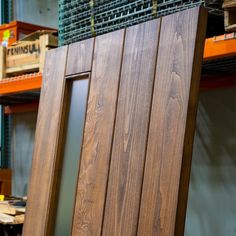 a wooden chair sitting on top of a hard wood floor next to shelves filled with boxes