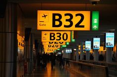 people are walking through an airport terminal with signs above them that read b32 and b38