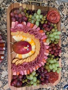 a platter filled with grapes, meats and other food on top of a table