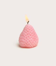 a small pink candle sitting on top of a white table