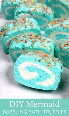 blue and white cake rolls with gold sprinkles in the middle on a marble counter